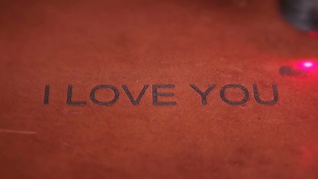 Laser machine engraves the inscription on the skin-I love you