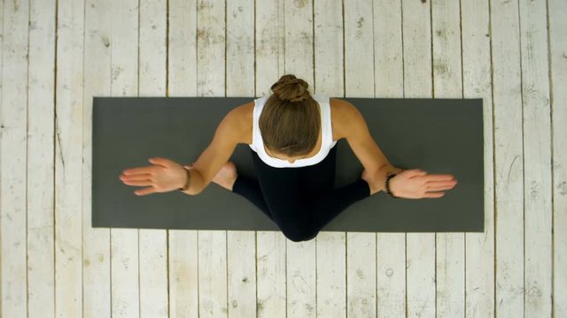 Sporty beautiful young woman practicing yoga, sitting in cross legged position