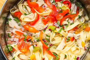 Chicken noodle soup in saucepan, closeup