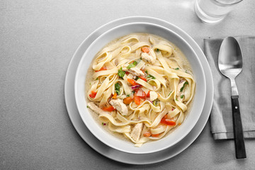 Chicken noodle soup in plate on kitchen table