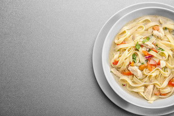 Chicken noodle soup in plate on grey background