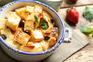 Delicious bread pudding with berries in bowl on napkin