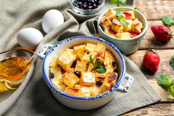Delicious bread pudding with berries in bowl on napkin
