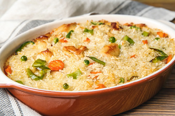 Tasty rice and chicken with vegetables in baking dish