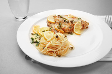 Plate with delicious Italian chicken piccata on table