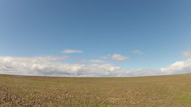 Time-lapse. Field against the sky with clouds in the spring
