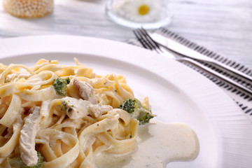 Delicious pasta alfredo with chicken on plate, closeup