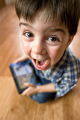 The boy with the tablet was very surprised at what he saw. Strong surprise. Optical distortion of the picture.