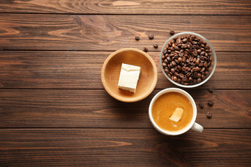 Composition with tasty butter coffee on wooden table