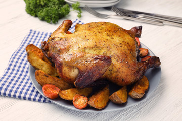 Plate with roasted beer can chicken on table