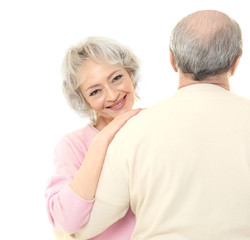 Happy senior woman embracing her husband on white background