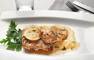 Tasty Italian chicken piccata with lemon on plate