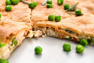 Piece of tasty chicken pot pie with green peas on plate, closeup