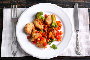 Chicken stir fry with vegetables and cutlery on table