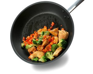 Chicken stir fry with vegetables in pan on white background