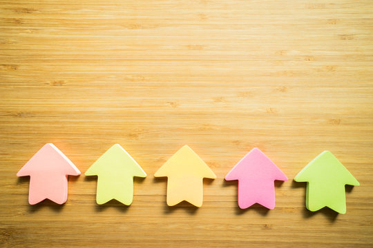 business concept. Arrow direction shape showing the increase of decrease of any subject on the wood texture background
