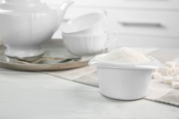 Fototapeta na wymiar White bowl with sugar on kitchen table