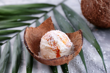 Plate with composition of ice cream ball in coconut shell, closeup