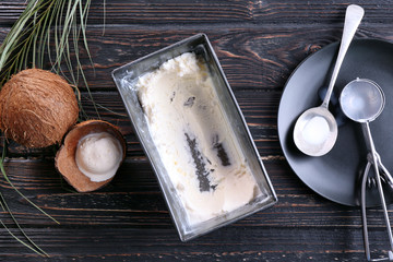 Metal tub with fresh ice cream for scooping and filling desserts on wooden background