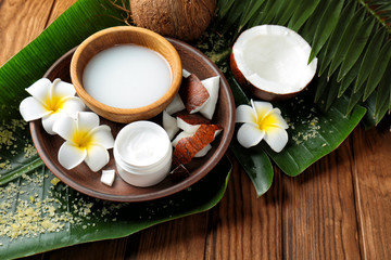 Composition with coconut milk and exotic flowers on wooden background