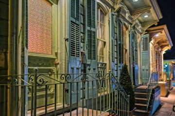 A colorful facade, entry doors in a row, and porches in The French Quarter of New Orleans.