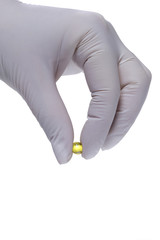Fototapeta premium Hand in latex glove holding a pill