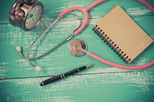 stethoscope and book on vintage wood background