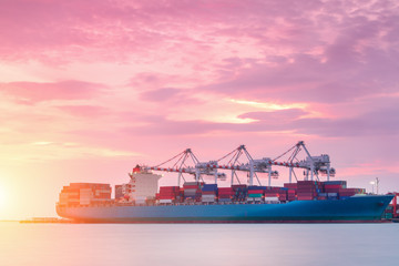 Container Cargo freight ship with working crane bridge in shipyard at dusk for Logistic Import Export background © Aunging