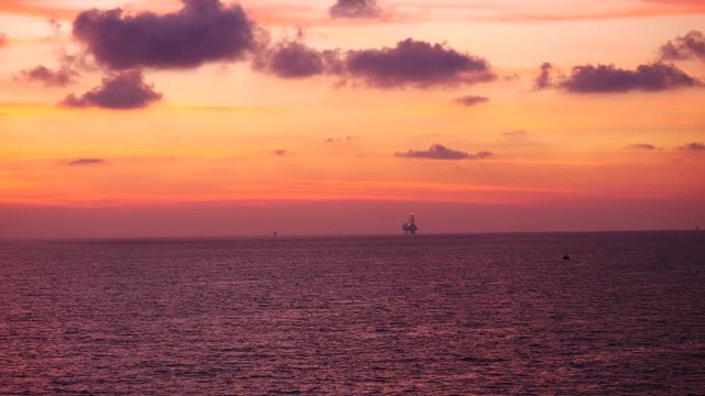 Jack up drilling rig in the middle of the ocean at sunrise time
