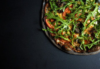 black carbon dough Italian pizza with roasted pumpkin salad rocket cheese for a holiday Halloween weekend menu