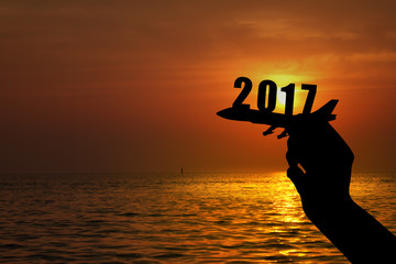 Silhouette of hand holding airplane for 2017 new year