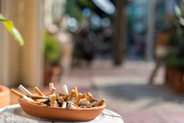 Many cigarette butts in a tray of sand to discard them