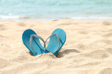 Fototapeta na wymiar Blue flip flop sandals on beach