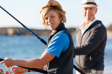 Senior man fishing with his grandson