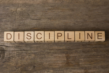word discipline written on cubes on wooden background