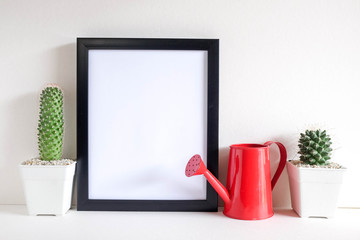 succulents or cactus in concrete pots over white background on the shelf and mock up frame photo