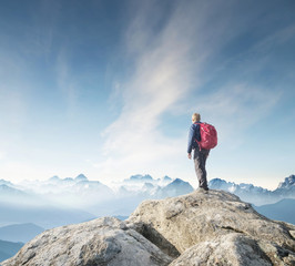 Obraz premium Tourist on the peak of high rocks. Sport and active life concept.