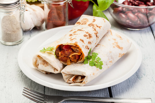 Mexican burritos wraps with mincemeat, beans and vegetables
