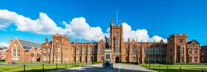 The Queen's University of Belfast with a grass lawn in sunset light. Wide panorama, - obrazy, fototapety, plakaty