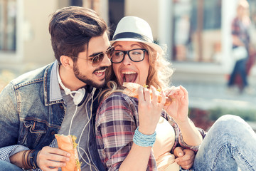 Young couple eating sandwich
