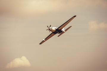 Single turboprop aircraft.. Small private plane flying in blue clouds. - obrazy, fototapety, plakaty