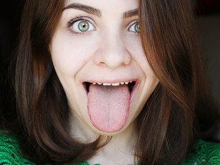 Naklejka premium Attractive girl showing a healthy tongue 