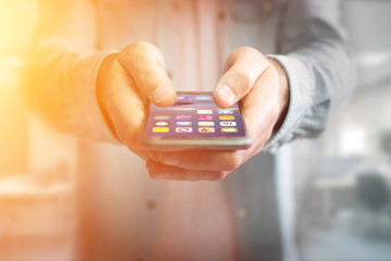 Hand holding black smartphone with operating system screen