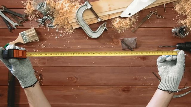 Top view craftsman hands showing tape-measure in action