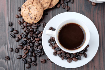 Coffee cup and coffee beans on wooden background