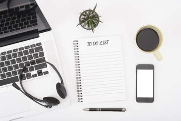 computer headset and coffee cup with to do list on desk from above, planning and schedule concept.