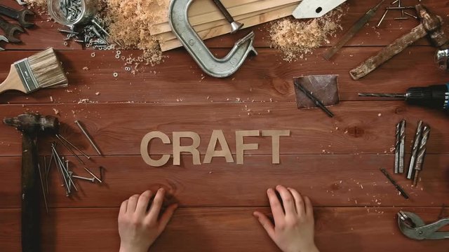 Top view time-lapse of a hand laying on wodden table word "CRAFT"