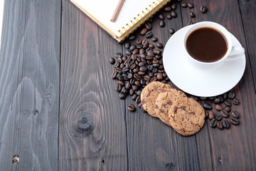 Coffee cup and coffee beans on wooden background