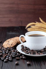 Coffee cup and coffee beans on wooden background