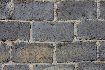 The texture of the background. An old wall of red cracked brick and cement with uneven masonry.